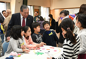 手作りの福笑いで遊ぶ子どもたちと高橋市長