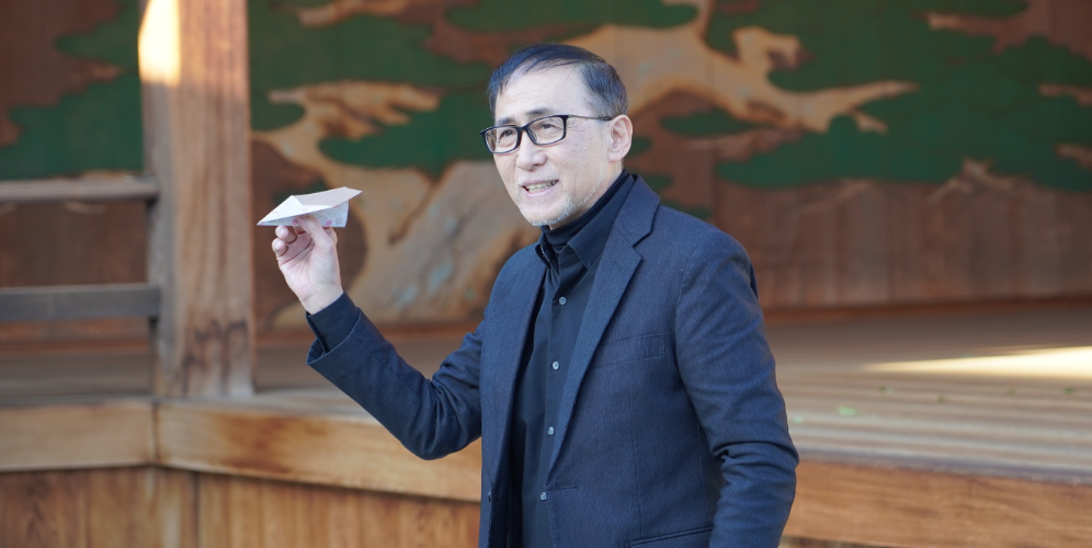 紙飛行機を持つ花房さん