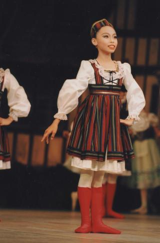 華やかな衣装でステージに立つ幼少期の石橋さん