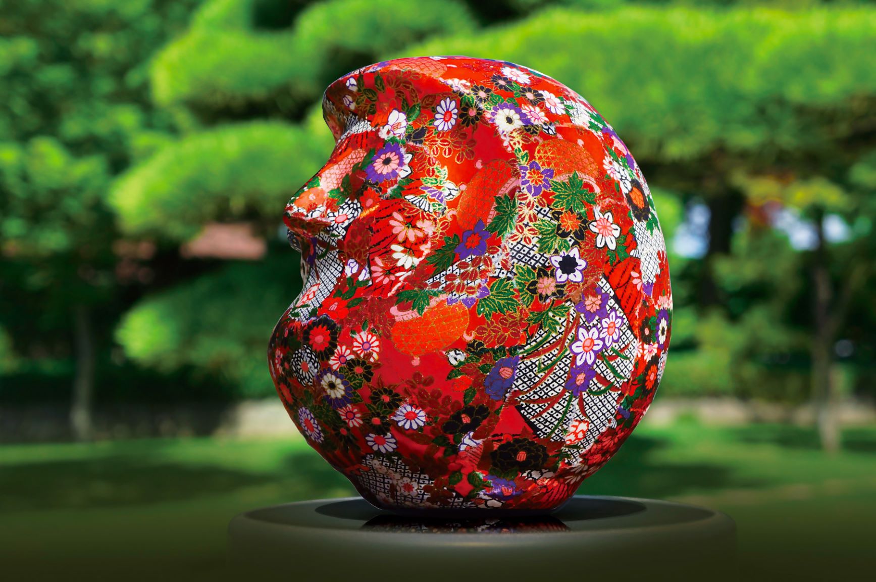 和柄の和紙や千代紙などを貼った赤色のだるまアートの写真