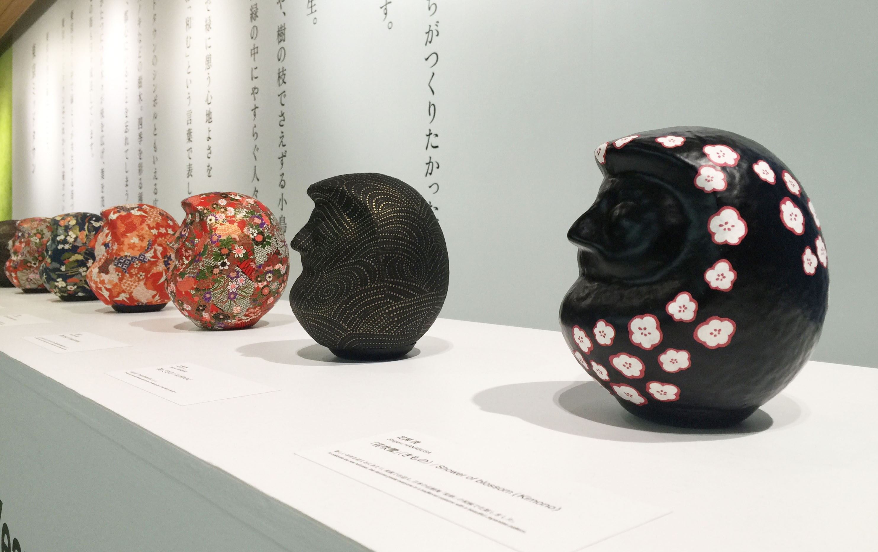 黒字に花びら模様や金のラインが入っただるまアートの写真