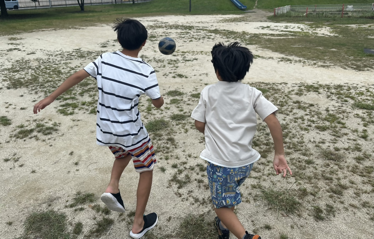 公園でボール遊びをする子どもたちの画像