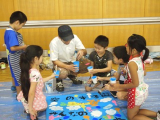 作成風景～矢生先生と一緒に看板を作る子供たち