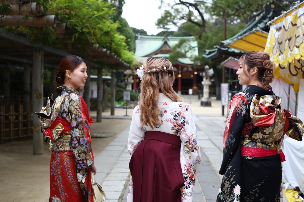 ナビゲーターである越谷市役所プロモーションZ係の3人の女性が神社の境内を歩いている写真